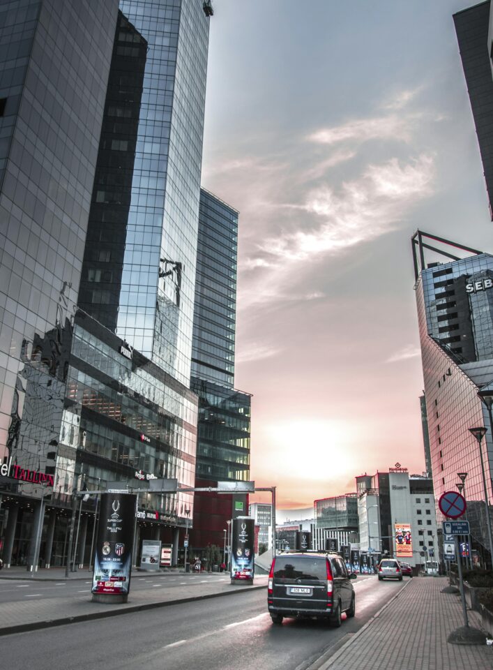 Urban cityscape of Tallinn with modern skyscrapers and sunset sky reflecting on buildings.